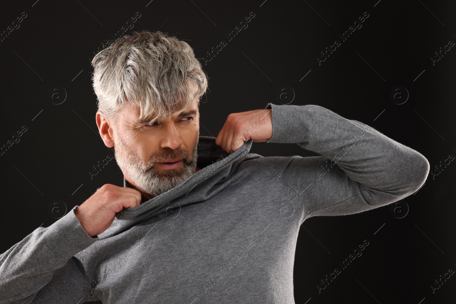 Photo of Portrait of man with beautiful hairstyle on black background