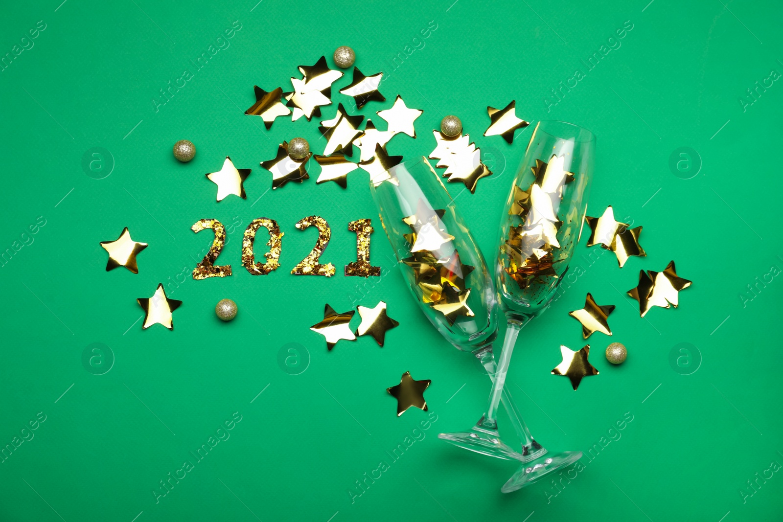 Photo of Flat lay composition with confetti and champagne glasses on green background. New Year celebration