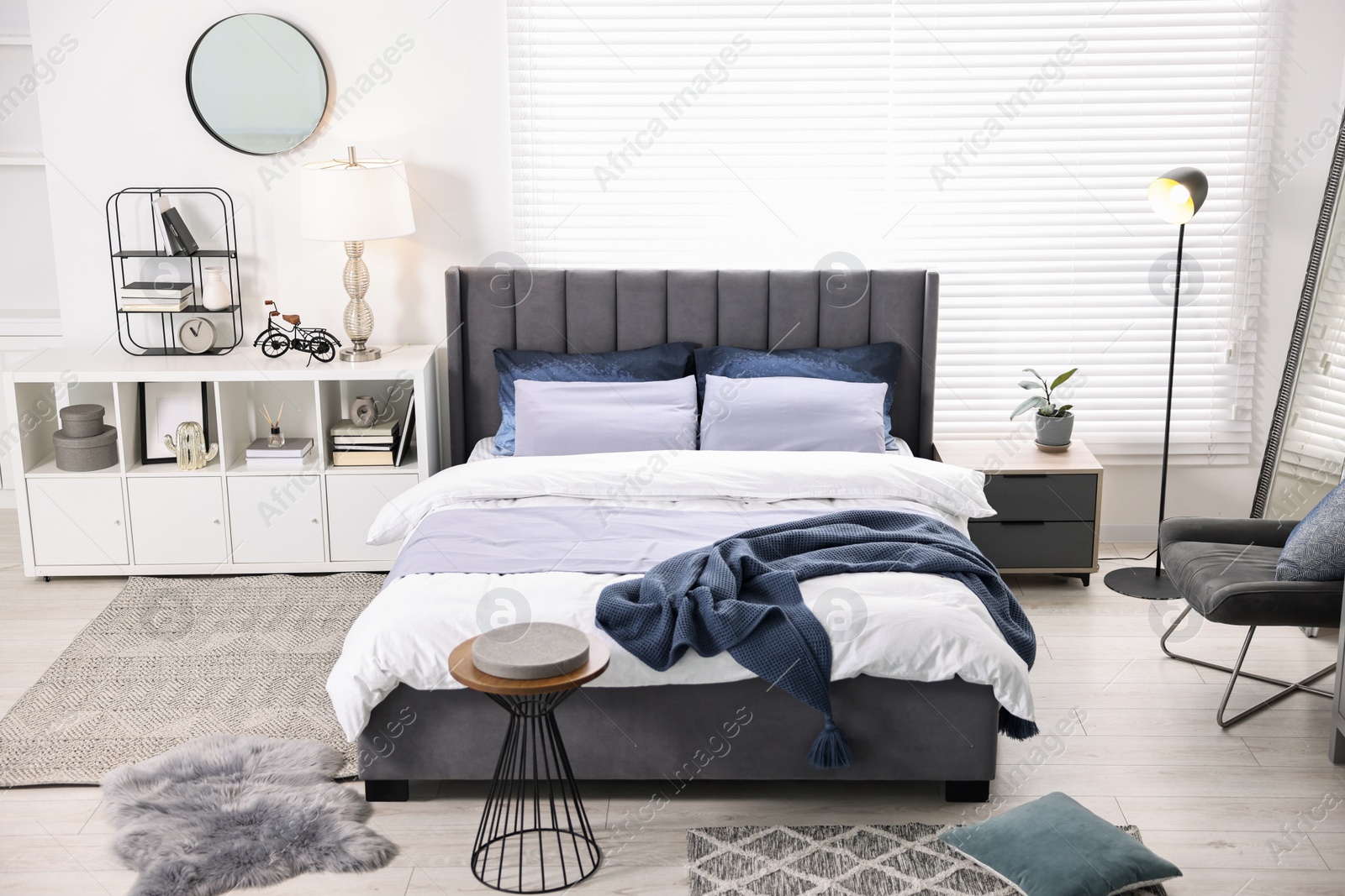 Photo of Bright plaid on bed in stylish bedroom. Interior design