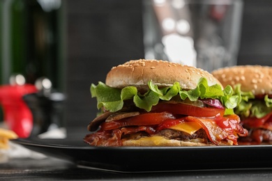 Plate with tasty burgers on table. Space for text