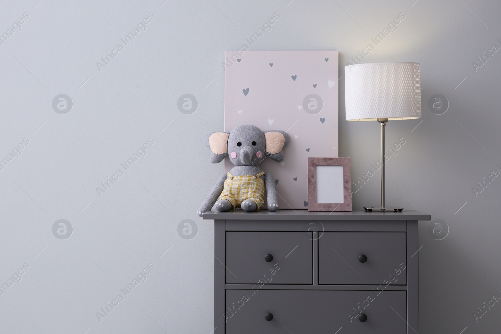 Photo of Modern grey chest of drawers near light wall in child room, space for text. Interior design