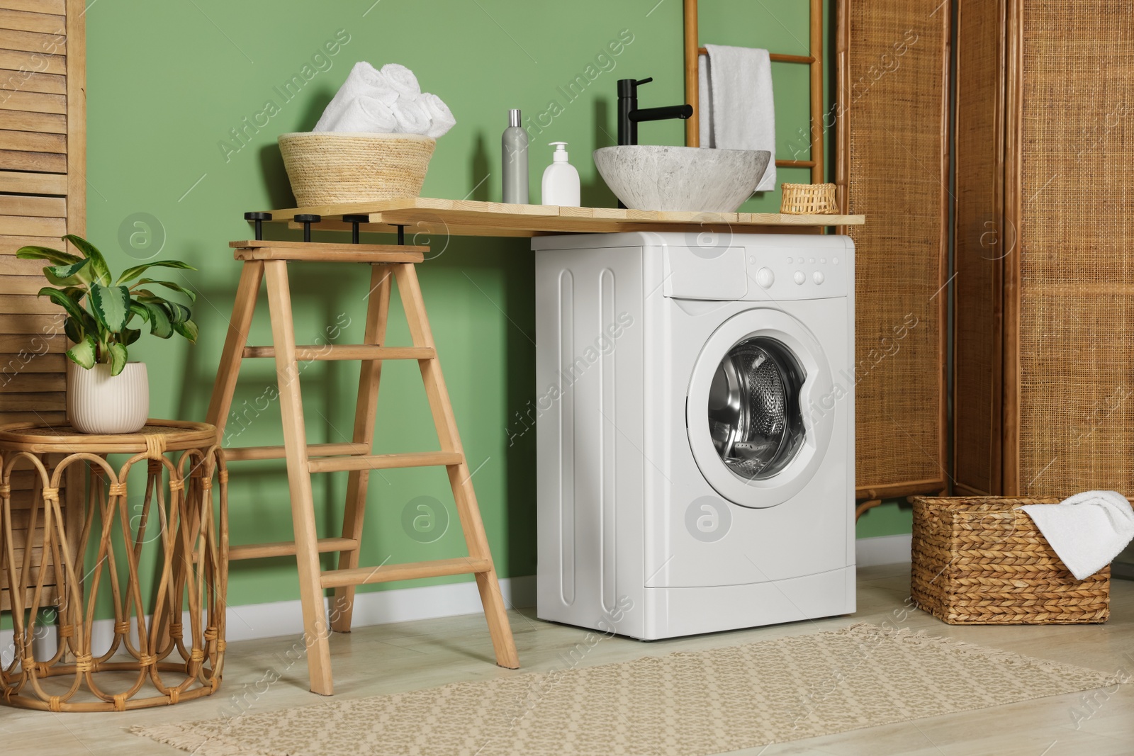 Photo of Stylish laundry room with functional washing machine. Interior design