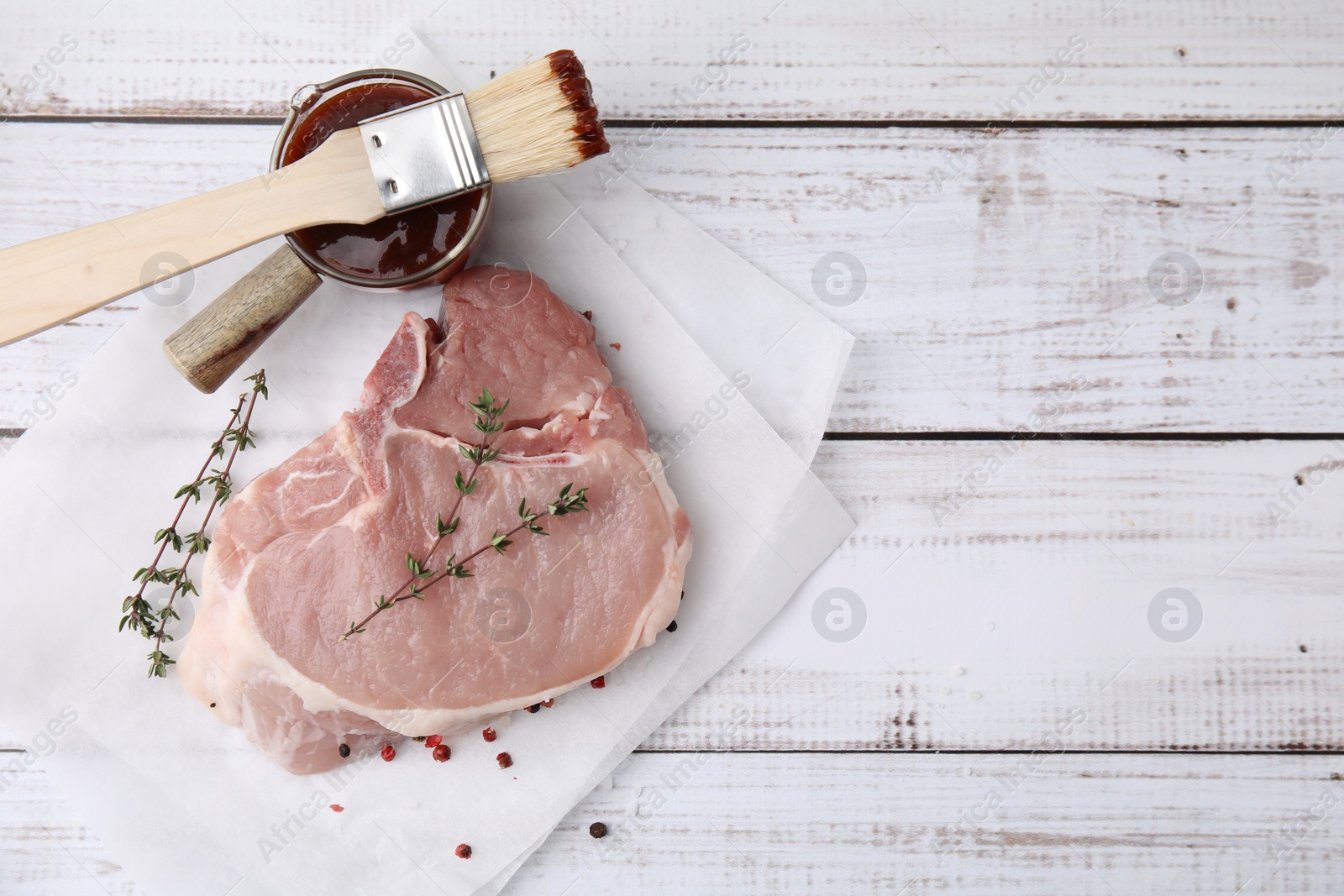 Photo of Raw meat, thyme and marinade on rustic wooden table, flat lay. Space for text