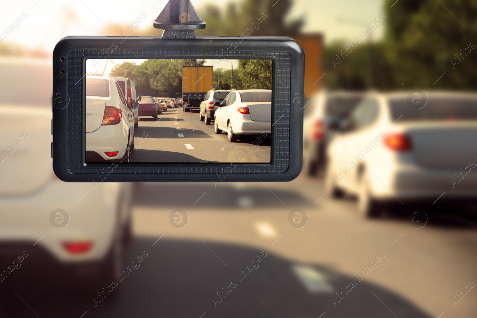 Image of Modern dashboard camera mounted in car, view of road during driving