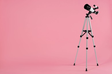 Tripod with modern telescope on pale pink background, space for text