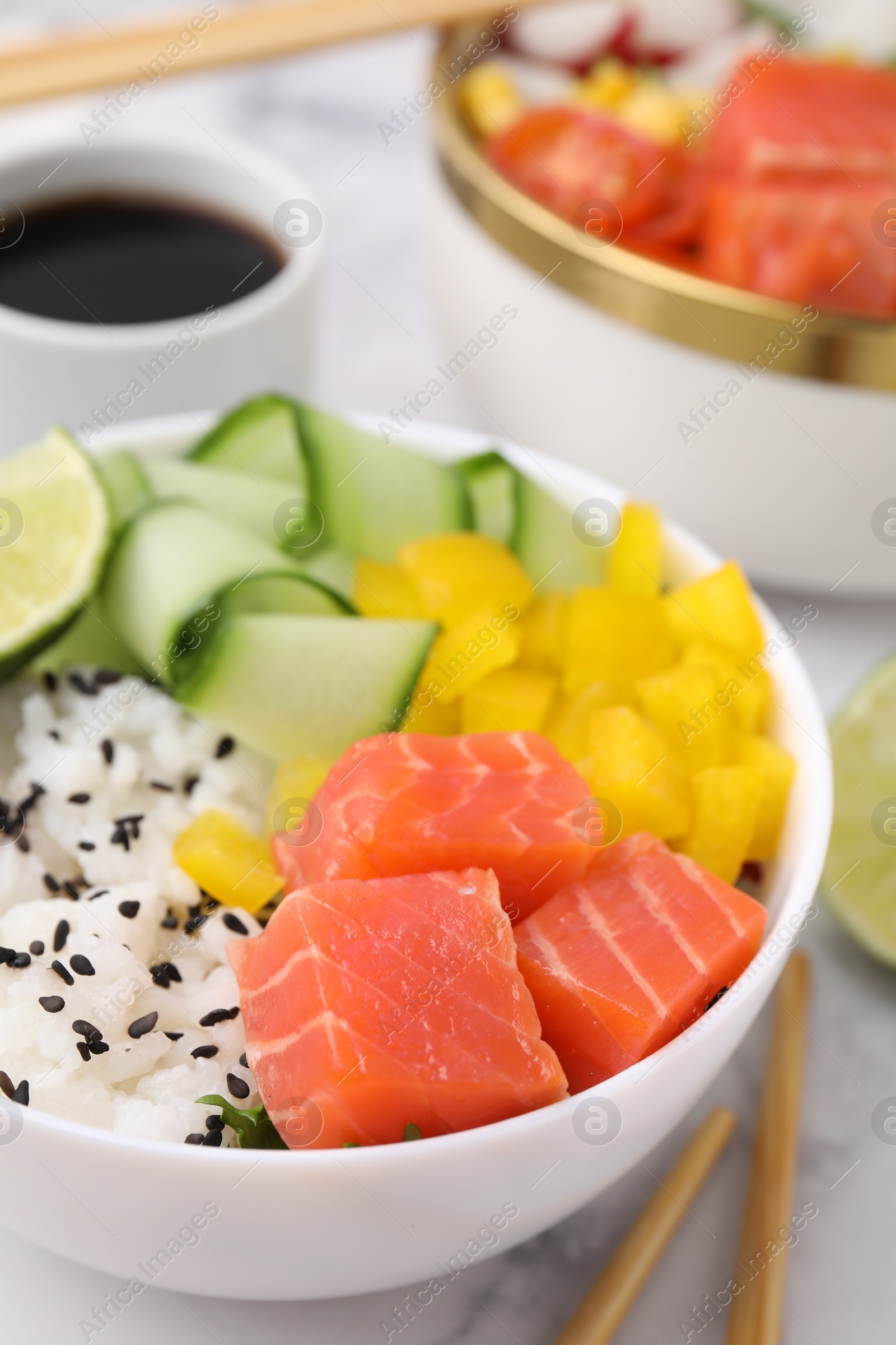 Photo of Delicious poke bowl with salmon, rice and vegetables on white table, closeup