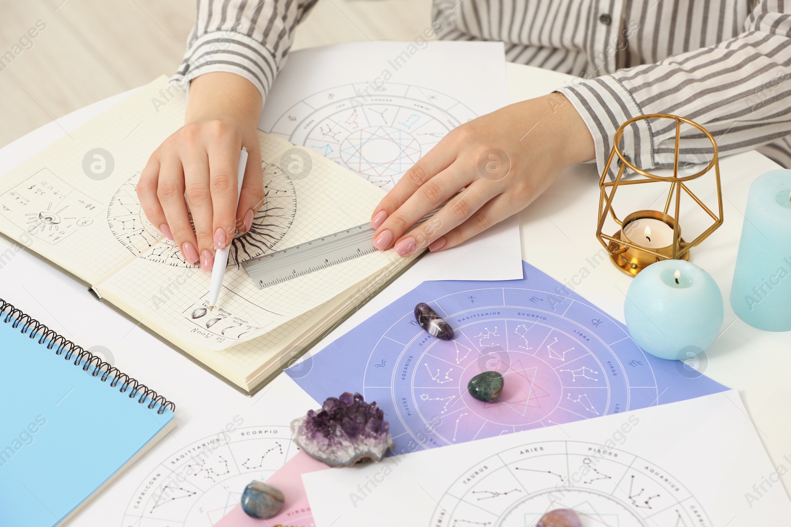 Photo of Astrologer using zodiac wheel for fate forecast at table, closeup. Fortune telling