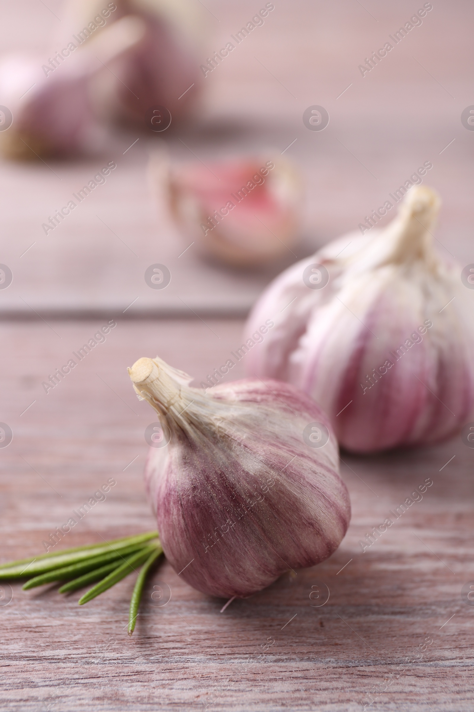 Photo of Bulbs of fresh garlic on wooden table, selective focus