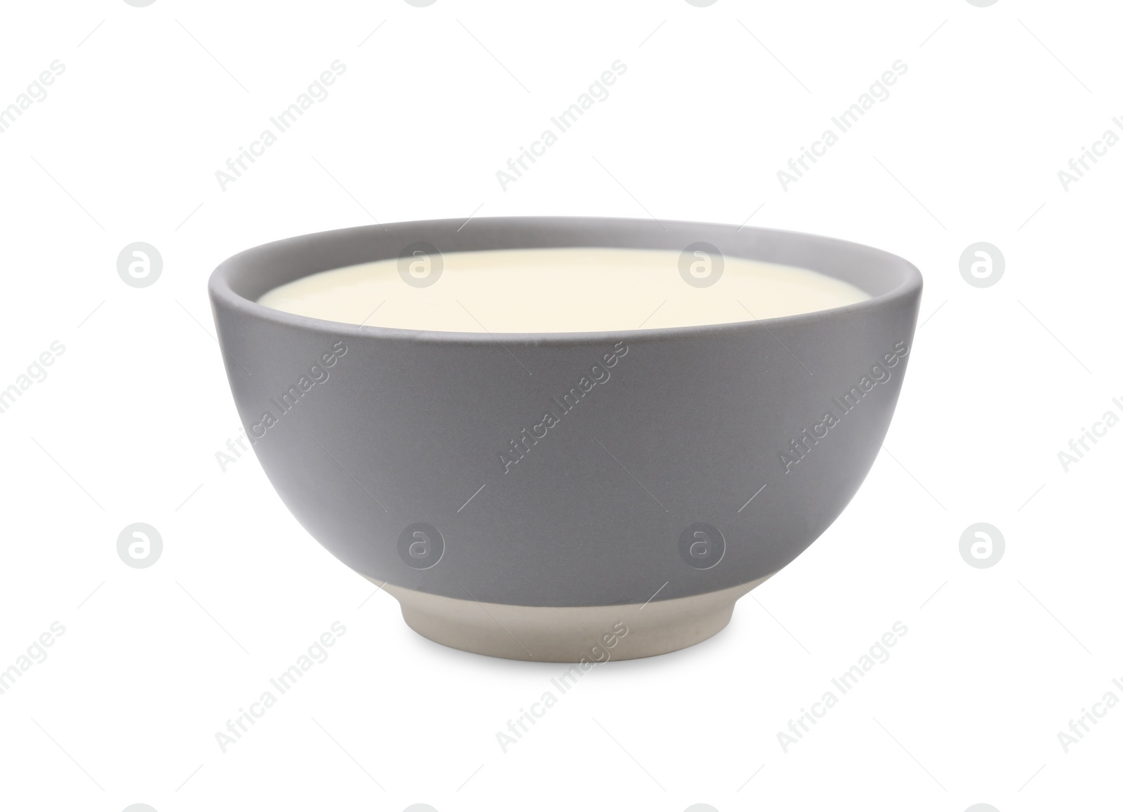 Photo of Bowl with condensed milk isolated on white