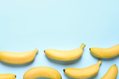 Photo of Sweet ripe baby bananas on turquoise background, flat lay. Space for text