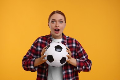 Photo of Emotional fan holding football ball on yellow background
