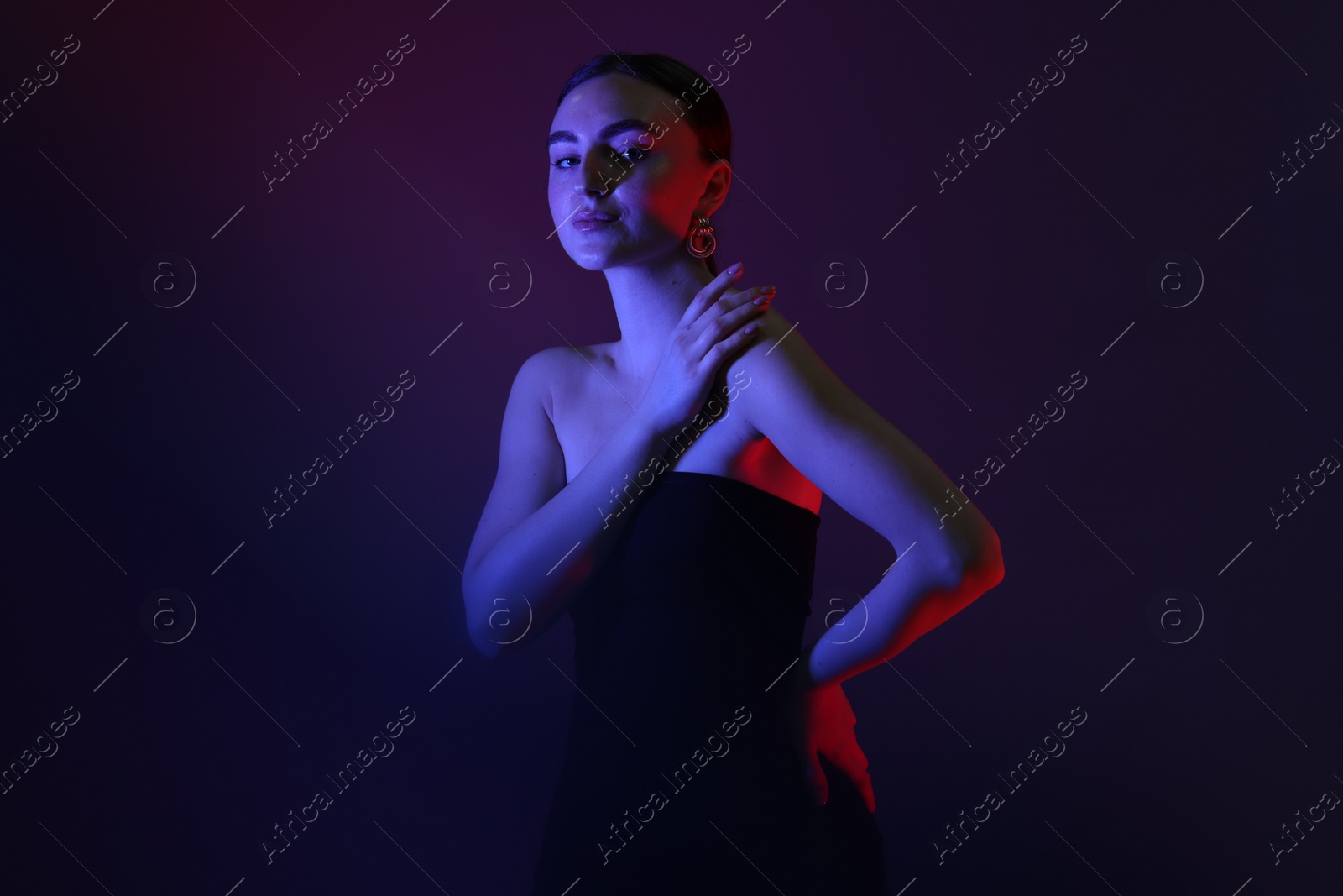 Photo of Portrait of beautiful young woman on color background in neon lights