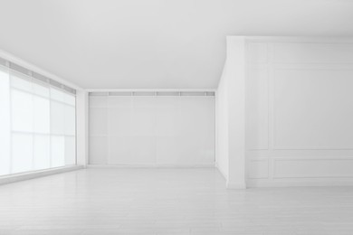 Photo of Empty room with white walls and laminated flooring