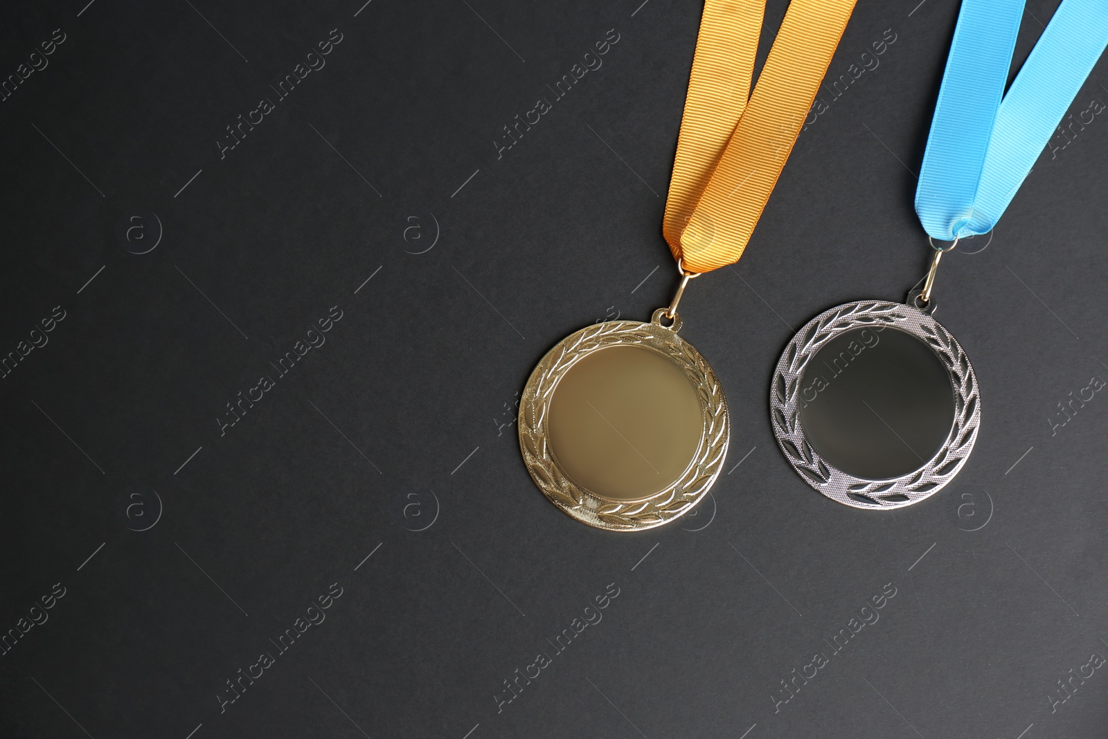 Photo of Gold and silver medals on black background, flat lay. Space for design