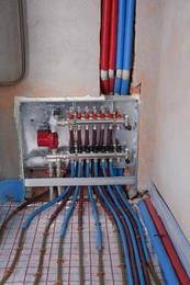 Underfloor heating system. Manifold with pipes in building