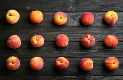 Fresh sweet peaches on black wooden table, flat lay