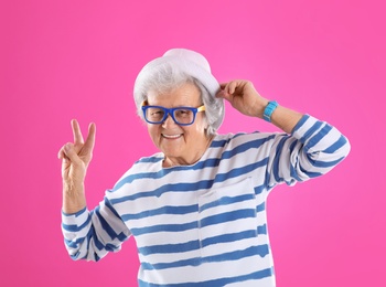 Photo of Portrait of cool grandmother on color background