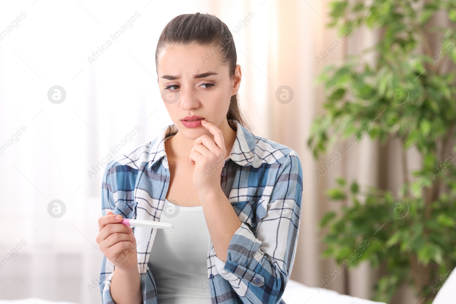 Photo of Young woman with pregnancy test at home. Gynecology and childbirth