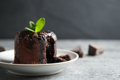 Photo of Delicious warm chocolate lava cake on grey table, closeup