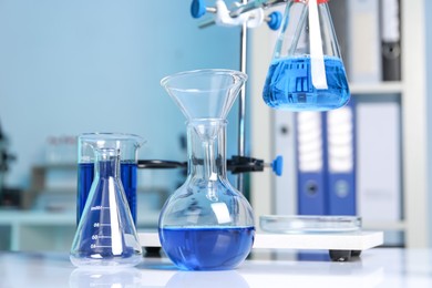 Photo of Laboratory analysis. Different glassware and stand on white table indoors