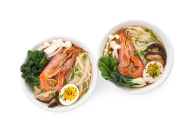 Photo of Delicious ramen with shrimps and eggs in bowls isolated on white, top view. Noodle soup