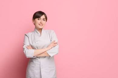 Photo of Cosmetologist in medical uniform on pink background, space for text