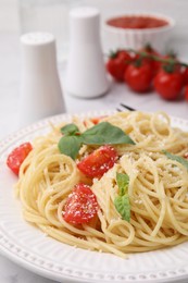 Tasty pasta with tomato, cheese and basil on table, closeup