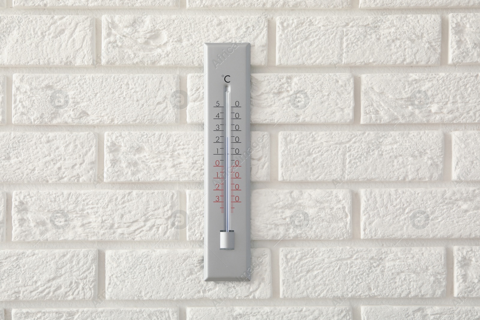 Photo of Weather thermometer hanging on white brick wall