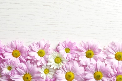 Photo of Beautiful chamomile flowers on wooden background, flat lay with space for text