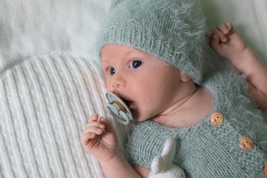 Photo of Cute newborn baby with pacifier on white blanket