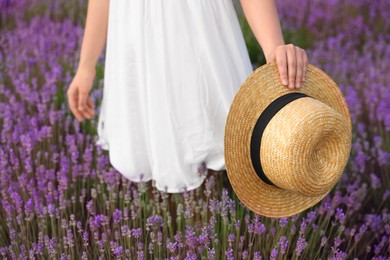 Photo of Young woman with straw hat in lavender field, closeup