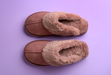 Photo of Pair of stylish soft slippers on violet background, flat lay