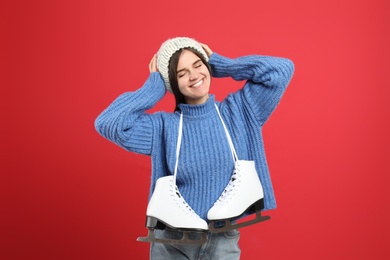 Photo of Happy woman with ice skates on red background