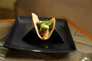 Photo of Delicious tacos with fresh ingredients on table