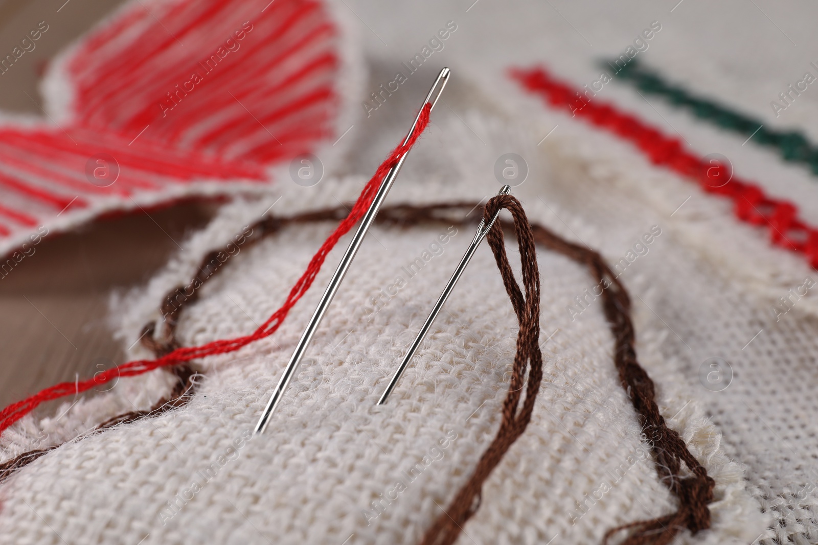 Photo of Heart made of burlap fabric, threads and needles, closeup