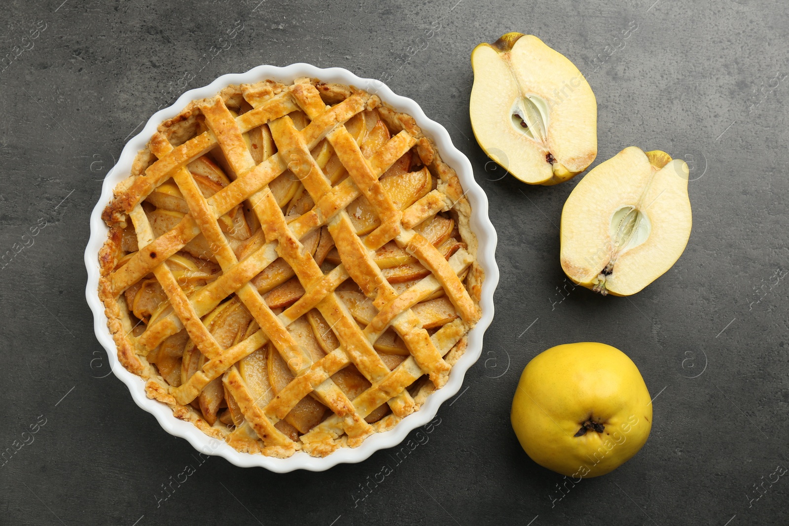 Photo of Tasty homemade quince pie and fresh fruits on grey table, flat lay