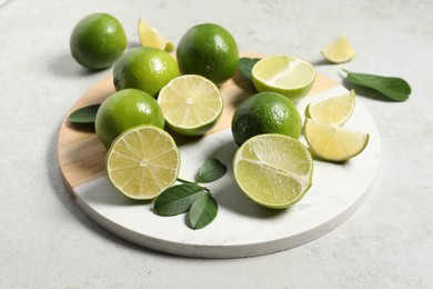 Fresh ripe limes and leaves on light table