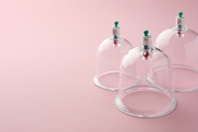 Photo of Plastic cups on pink background, space for text. Cupping therapy