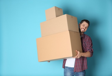 Photo of Man with moving boxes on color background. Space for text