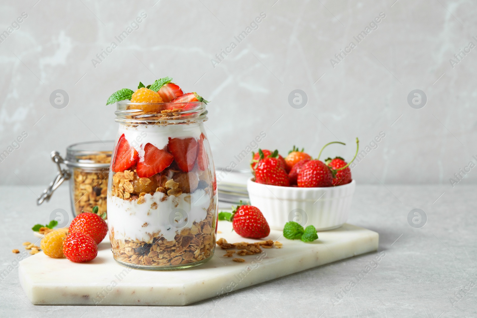 Photo of Tasty homemade granola dessert served on grey table, space for text. Healthy breakfast