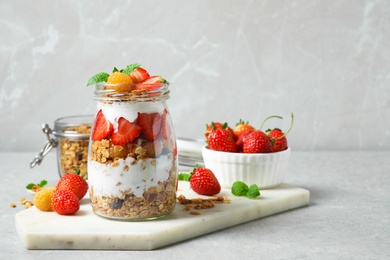 Tasty homemade granola dessert served on grey table, space for text. Healthy breakfast