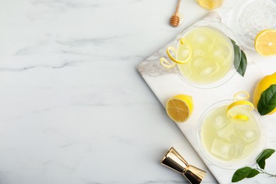 Photo of Delicious bee's knees cocktails and ingredients on white table, flat lay. Space for text