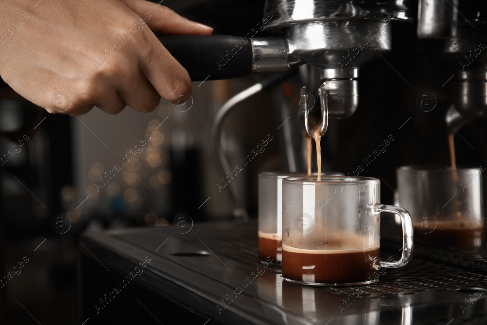 Photo of Barista making espresso using professional coffee machine, closeup