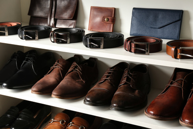 Photo of White shelving unit with different leather shoes and accessories