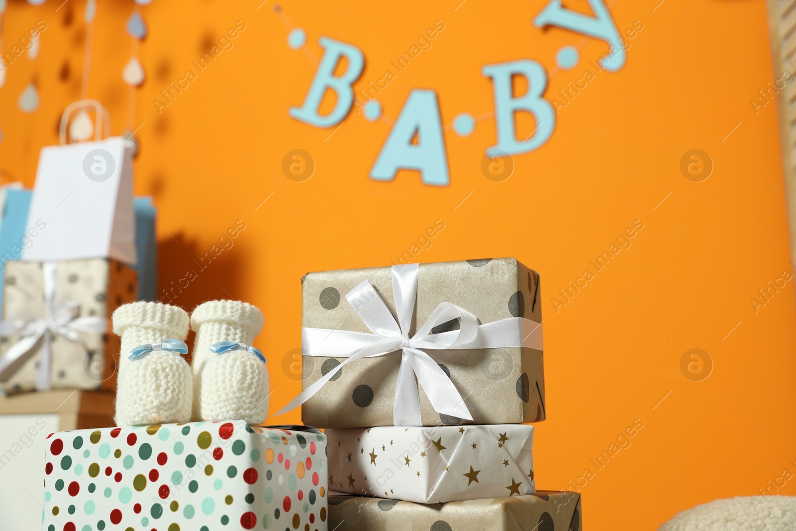 Photo of Baby shower party. Festive decor, booties and gift boxes in stylish room, space for text