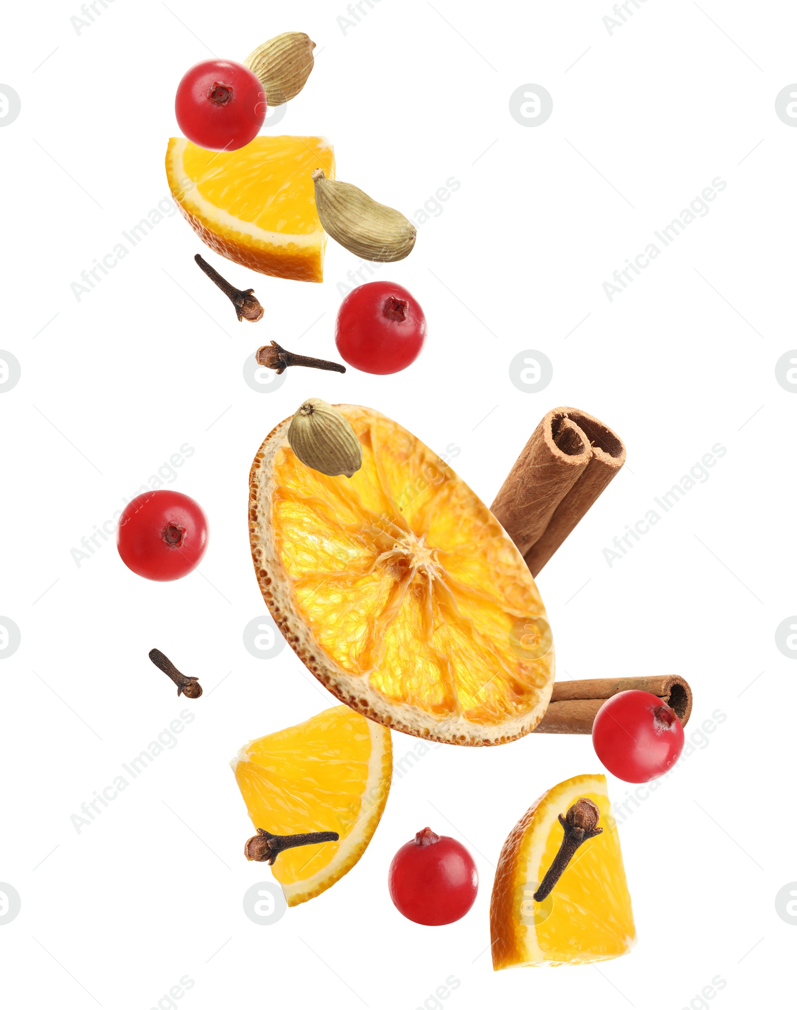Image of Cut orange, cranberries and different spices falling on white background. Mulled wine ingredients