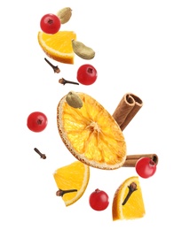 Image of Cut orange, cranberries and different spices falling on white background. Mulled wine ingredients