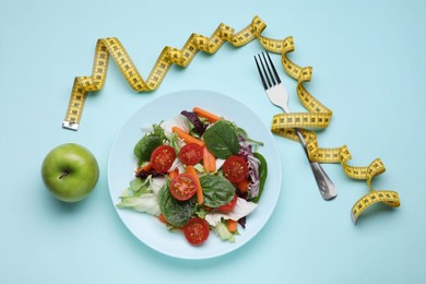 Photo of Measuring tape, vegetable salad and apple on light blue background, flat lay. Weight loss concept