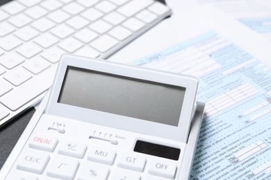 Photo of Calculator, document and keyboard on black table, closeup. Tax accounting