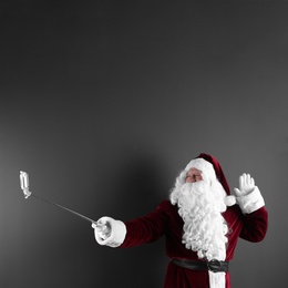 Photo of Authentic Santa Claus taking selfie on grey background